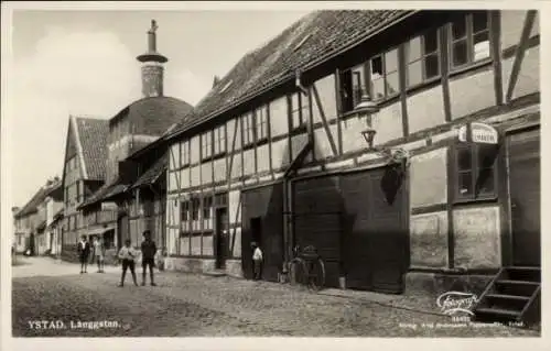 Ak Ystad Schweden, Historische Straßenansicht, Fachwerkhäuser, Rad, Personen, Laterne