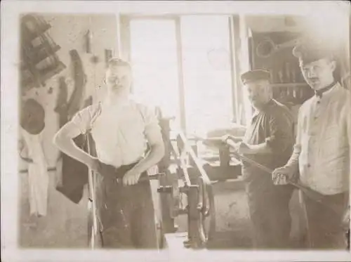 Foto Drei Arbeiter in einer Werkstatt