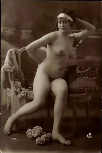 Ak Frauenakt, auf einem Sofa sitzend