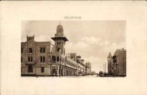 Ak Heliopolis Cairo Kairo Ägypten, Eine Straßenansicht von Heliopolis mit Gebäuden im Hintergr...