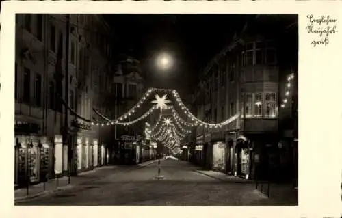 Ak Zittau in Sachsen, Nachtaufnahme einer beleuchteten Straße, Weihnachtsdekoration, Mond sich...