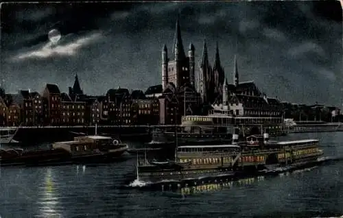 Ak Köln am Rhein, Nachtszene mit dem Kölner Dom, beleuchteten Gebäuden, einem Schiff