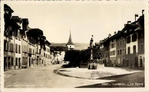 Ak Le Landeron Kanton Neuenburg,  Le Bourg, Straßenansicht, Brunnenskulptur, Häuserreihe, Land...