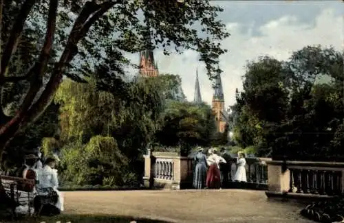 Ak Oldenburg in Holstein, Schlossgarten, Menschen in historischer Kleidung, Bäume, Gebäude im ...