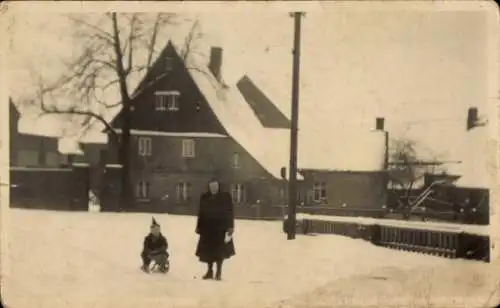 Foto Ak Großsteinberg Parthenstein in Sachsen, Schnee, Kind auf Schlitten, Wohnhaus