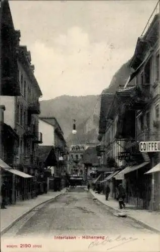 Ak Interlaken Kanton Bern Schweiz, Straße in  Höhenweg, Geschäfte, Berge im Hintergrund