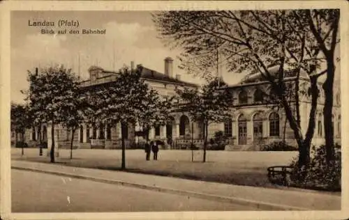 Ak Landau in der Pfalz, Blick auf den Bahnhof, historische Architektur, Bäume, zwei Personen