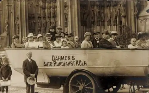 Ak Köln am Rhein, Gruppe von Menschen im offenen Bus, Kathedrale im Hintergrund, historische A...