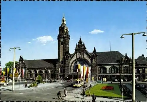 Ak Krefeld am Niederrhein, Hauptbahnhof  Gebäude mit Uhrturm, Menschen, Pflanzenbeete, Fahnen