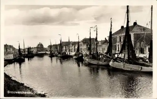 Ak Brouwershaven Zeeland,  Schiffe im Wasser, Häuserreihe, bewölkter Himmel