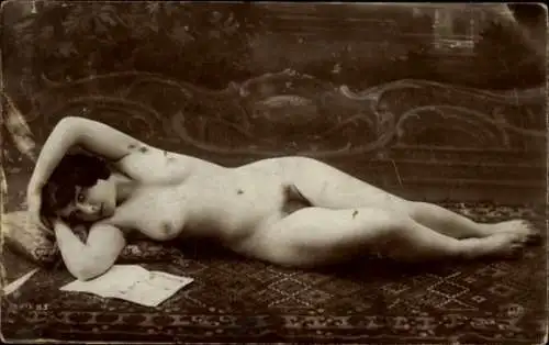 Foto Ak Frauenakt, auf einem Teppich liegend