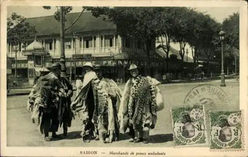 Ak Ho Chi Minh Stadt Saigon Vietnam, Fünf Händler mit Tierhäuten, Stadtansicht im Hintergrund