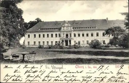 Ak Ohorn in Sachsen, Großes, historisches Gebäude, Garten, Tisch und Stühle im Vordergrund