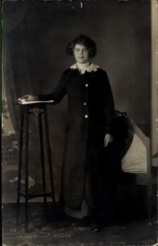 Ak Straßburg Elsass Bas Rhin, Eine junge Frau steht vor einem Podest mit einer Hand darauf. Si...