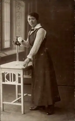 Foto Ak Frau in schwarzem Kleid, Blumenvase