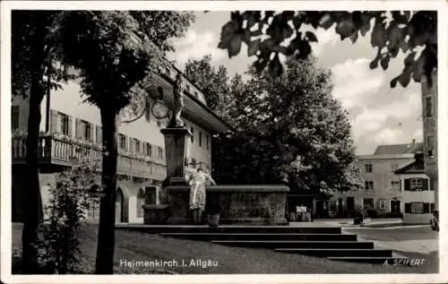 Ak Heimenkirch im Allgäu, Brunnen, Gebäude, Bäume, Wolken, Schwarz-Weiß-Fotografie