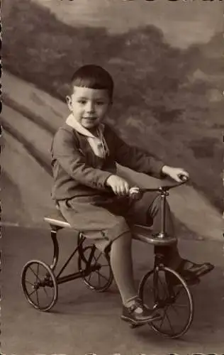 Foto Ak Kleiner Junge mit Dreirad