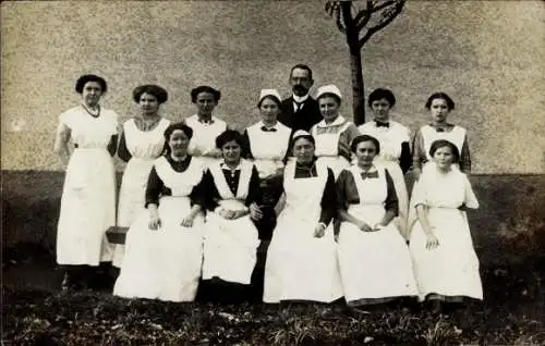 Foto Ak Frauen in Schürzen, Gruppenfoto, Mann in schwarzen Anzug