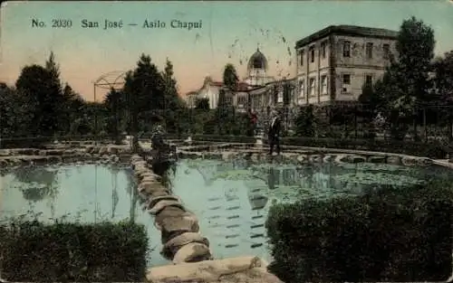 Ak San Jose Costa Rica, Vorderansicht des Asilo Chapui, Teich, grüne Bepflanzung, Personen