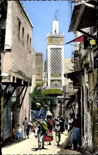 Ak Fes el Bali Fez Marokko, Markante Altstadtgasse, minarettartige Architektur, Menschen und K...