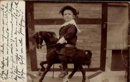 Foto Ak Kind auf einem Holzpferd, Portrait
