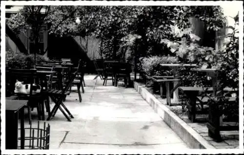 Ak Wien 9 Alsergrund Österreich, Gartenrestaurant, leere Terrassenmöbel, Katze auf dem Stuhl