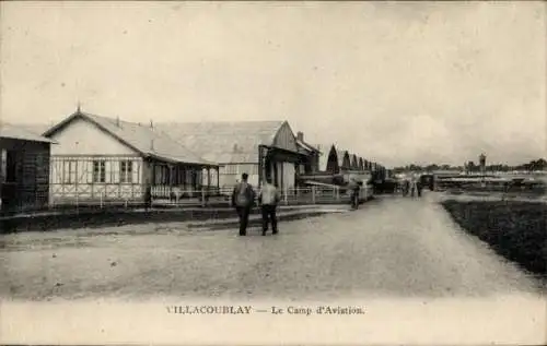 Ak Vélizy Villacoublay Yvelines, Le Camp d'Aviation, zwei Männer spazieren, Gebäude im Hintergrun
