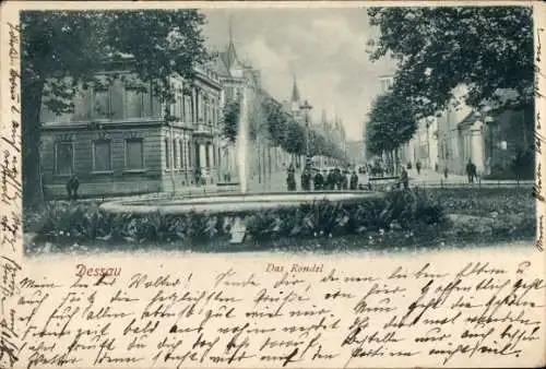 Ak Dessau in Sachsen Anhalt, Brunnen, Straßenansicht, historische Gebäude, Menschen, handschri...