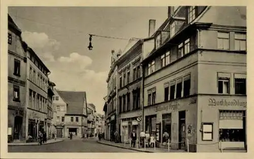 Ak Lutherstadt Eisleben, Straße mit Buchhandlung, Menschen, Gebäude, Lampen, Wolken