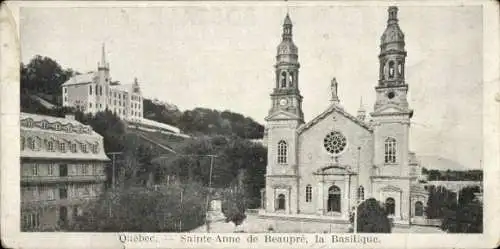 Ak Sainte Anne de Beaupré Québec Kanada, Basilika, zwei Türme, Gebäude im Hintergrund, Landschaft