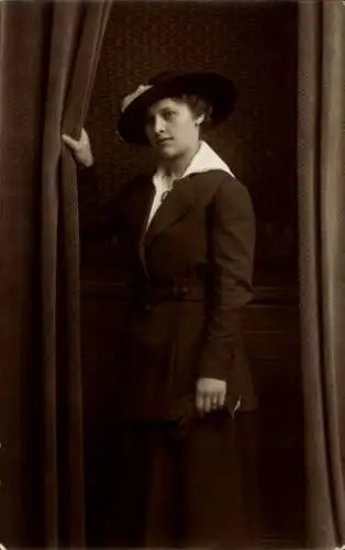 Foto Ak Eine junge Frau steht vor einem Vorhang, Porträt