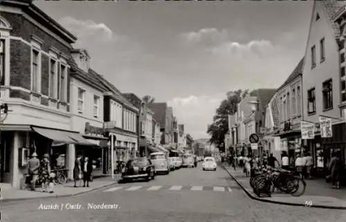 Ak Aurich in Ostfriesland, Straße in  Ostfriesland, Gebäude, Menschen, Autos, Fahrräder