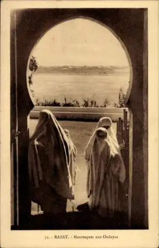 Ak Rabat Marokko, Verschleierte Frauen stehen in einem Torbogen. Im Hintergrund ist eine Stadt...