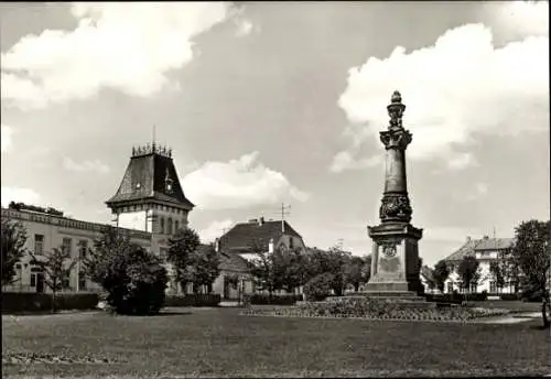 Ak Putbus auf der Insel Rügen, Marktplatz mit Denkmal, Gebäude im Hintergrund, Bäume