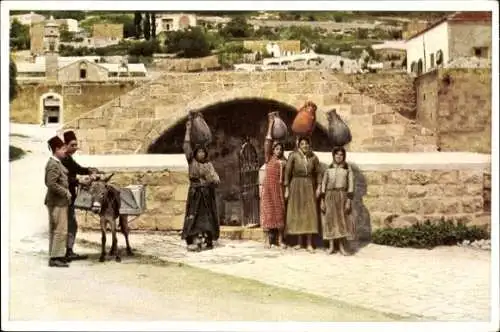 Ak Nazaret Nazareth Israel, Brunnen, Frauen mit Lasten, Mann mit Esel, traditionelle Kleidung
