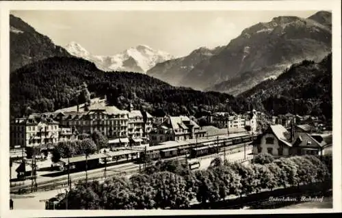 Ak Interlaken Kanton Bern Schweiz, Bahnhof  Berge im Hintergrund, Architektur, Zugverkehr