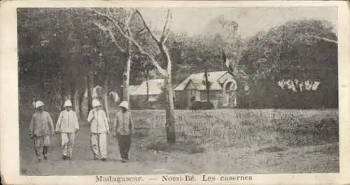 Ak Nosy Be Nossi Be Madagaskar, Vier Personen im Militäroutfit, Gebäude, Bäume, Straße