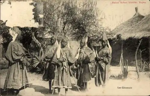 Ak Kayes Mali, 5 Männer in traditioneller Kleidung, Strohdachhäuser im Hintergrund, Fotografiert 