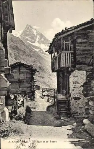 Ak Zinal Kanton Wallis, Berglandschaft, Holzhäuser, schmaler Weg, hoher Gipfel im Hintergrund