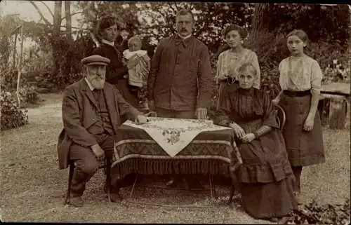 Foto Ak Gruppenbild, Familie an einem Tisch im Garten, Thede, Lars A. Müller