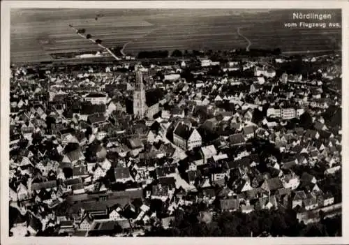 Ak Nördlingen in Schwaben, Luftaufnahme von  Stadt mit vielen Häusern, Kirche sichtbar