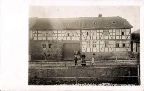 Foto Ak Frau mit Kindern vor Fachwerkhaus