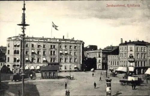 Ak Kristiania Christiania Oslo Norwegen, Jernbanetorvet,  Gebäude, Flagge, Marktplatz