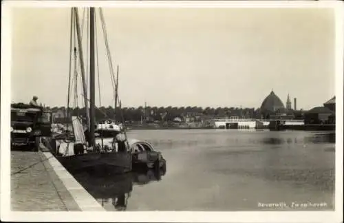 Ak Beverwijk Nordholland Niederlande, Hafenansicht, Boote am Pier, ruhiges Wasser,  Gebäude im Hi