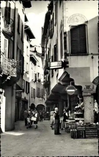 Ak Lugano Kanton Tessin Schweiz, schmale Gasse, alte Gebäude, Menschen auf der Straße, Marktständ
