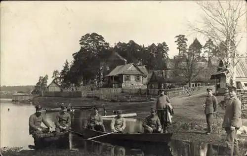 Foto Ak Soldaten am Ufer, Boot, Dorf, Ostfront