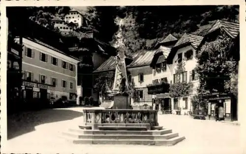 Ak Hallstatt im Salzkammergut Oberösterreich, Marktplatz mit Brunnen,  Gebäude, Berge im Hintergr