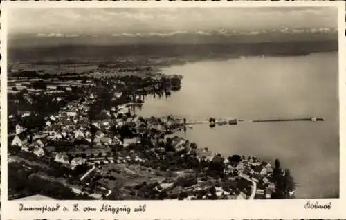 Ak Immenstaad am Bodensee, Luftaufnahme von  Bucht, Wasser, Berge im Hintergrund, Häuser,(Schwäbi