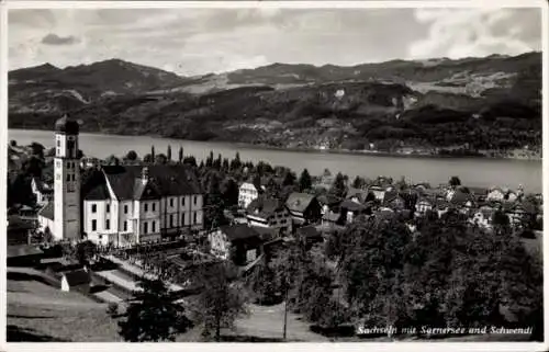 Ak Sachseln Kt. Obwalden, Ansicht von  Sarnersee im Hintergrund, Berge, Kirche