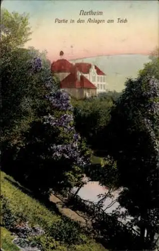 Ak Northeim in Niedersachsen, Historisches Gebäude, Teichblick, Blumenbäume, friedliche Gartenlan
